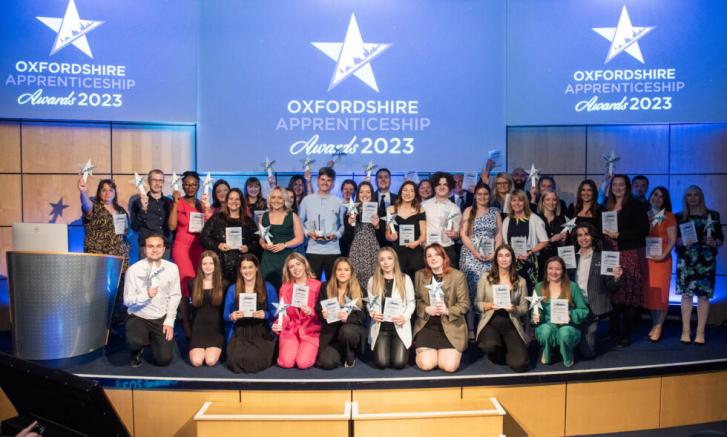 Photo of 2023 Oxfordshire Apprenticeship Awards winners on stage under banner