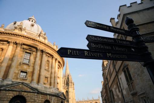 Image of historic University of Oxford Radcliff Camera next to university signage 